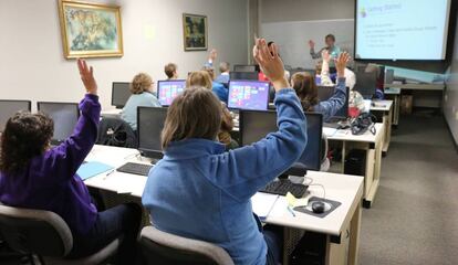 Alumnos en un aula con ordenadores.
