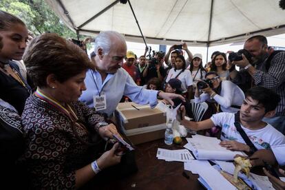 O ex-presidente de Colômbia Andrés Pastrana (centro) recolhe um documento na mesa de votação durante a consulta popular impulsionada pelos opositores do presidente Nicolás Maduro em Caracas (Venezuela).