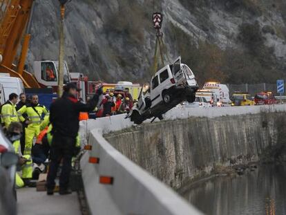 Una gr&uacute;a saca la furgoneta accidentada del agua. 