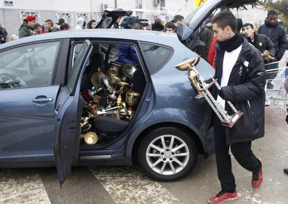 Un jugador guarda en el maletero de un coche los trofeos que el club, histórico de las categorías regionales, ha ido atesorando durante sus 50 años de vida. El Aviación tiene actualmente tiene 110 socios y entrena a una decena de equipos.