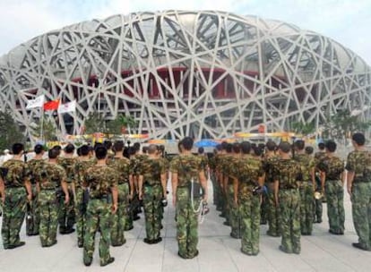 Un grupo de militares chinos hace guardia frente al Estadio Nacional.