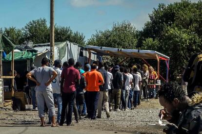 Migrantes hacen cola para conseguir comida, en el campo de refugiados de Calais. Una de las medidas de control que ha pedido el Gobierno regional tras la "degradación" de la situación en el campo es la prohibición de salida de migrantes por las noches, para disuadir a quienes tratan de subir clandestinamente a los camiones que se dirigen al Reino Unido.