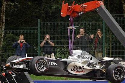 Un grúa retira el coche de Montoya de la pista tras su accidente con Pizzonia.