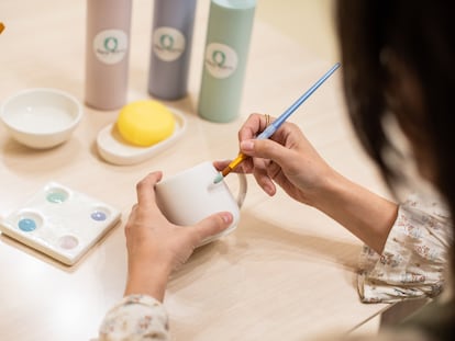 Una persona pinta una taza de cerámica en Mama Pottery, en el distrito Centro de Madrid.