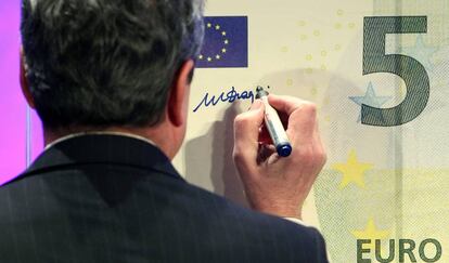 El expresidente del Banco Central Europeo, Mario Draghi, firmando un billete de cinco euros.