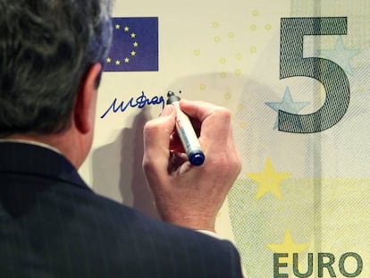 El ex presidente del Banco Central Europeo, Mario Draghi, firmando un billete de cinco euros. 