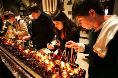 Unos jóvenes encienden velas por el Papa en la catedral de San Patricio en Nueva York.