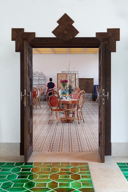 The entrance to the dining room, with bespoke 'vermelho [vermillion]' pavement made at the Azeitão tile factory, which has been in operation in Portugal since the 16th century. Maison Gatti of Paris produced the colorful rattan bistro chairs. 