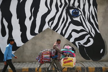 Un vendedor ambulante utiliza su bicicleta para vender la mercancia en una calle de Lalitpur (Nepal), el 9 de abril de 2018.