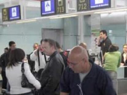 Varias personas descansan hoy en la T1 del aeropuerto de El Prat (Barcelona)