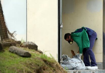 Un técnico forense revisa el cadáver de un prisionero en un camión refrigerado en el Instituto de Ciencias Forenses en Manaos (Brasil), el 28 de mayo de 2019. Al menos 40 prisioneros en Brasil fueron estrangulados el lunes en cuatro cárceles de la ciudad del Amazonas, tras una pelea entre pandillas rivales el día anterior que dejó 15 muertos.