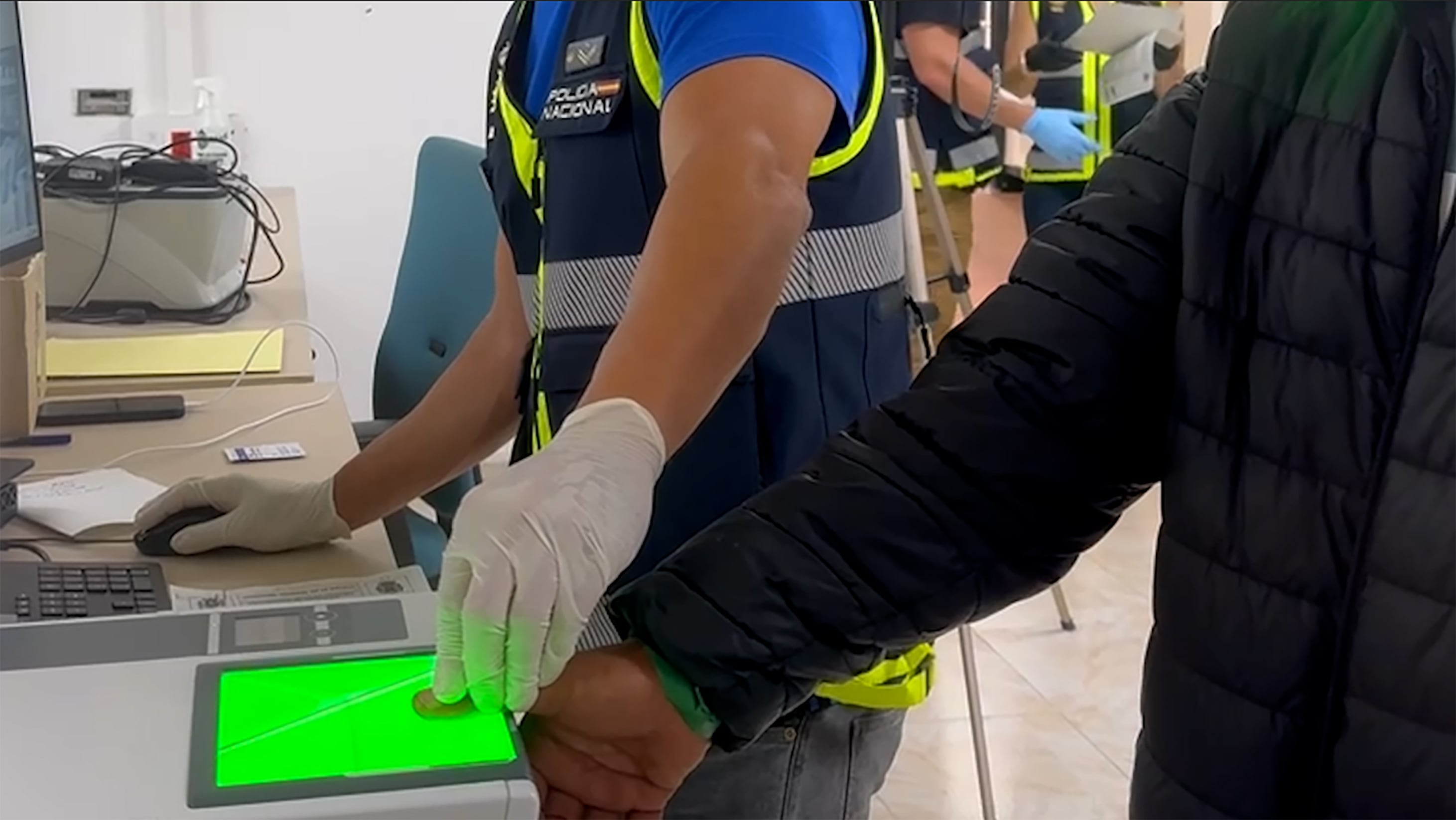Agentes de Policía toman las huellas a migrantes en las instalaciones de Ceuta.