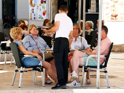 Un camarero atiende a varios clientes en una terraza en Valencia en 2021.