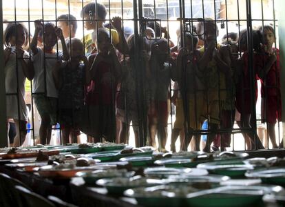 Niños esperan a las puertas de un centro religioso para comer en un distrito pobre de Manila (Filipinas).