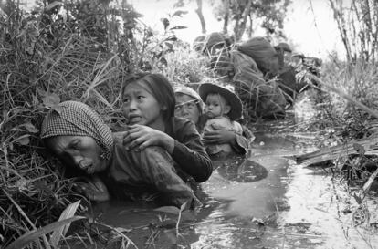 Mujeres y niños vietnamitas se refugian en un canal del intenso fuego del Viet Cong, en Bao Trai, el 1 de enero de 1966.