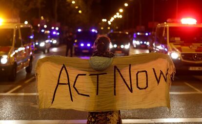 Una manifestante, con una pancarta con el lema "act now" (actúa ahora, en castellano), este viernes en la marcha por el clima en Madrid.