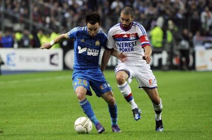 Mathieu Valbuena lucha por el balón con Lisandro