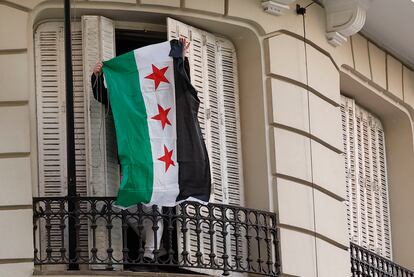 Una persona enarbola la bandera rebelde después de quitar la de la República Árabe Siria en la Embajada de dicho país en Madrid, el 8 de diciembre.
