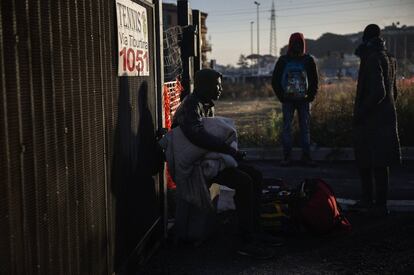 Varios migrantes permanecen cerca de la fbrica abandonada tras el desalojo.