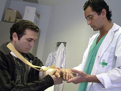 El doctor Pedro Cavadas (derecha) mientras observaba ayer el brazo izquierdo de Israel Sarrió.