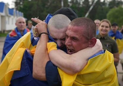 Dos prisioneros de guerra ucranios se abrazan después de ser liberados en un intercambio de presos entre Rusia y Ucrania, este lunes.