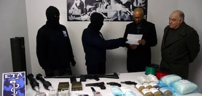 Hooded ETA members hand over an inventory of weapons to a verification group in February 2014.