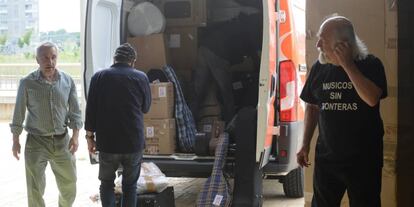 Miembros de las asociaciaciones colaboradoras cargan la furgoneta con  los instrumentos.