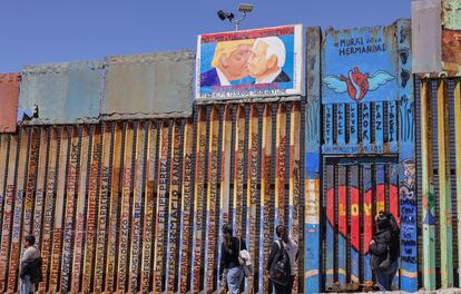 En el muro fronterizo que separa las ciudades de Tijuana y San Diego, un grupo de activstas ha colocado una pintura de Donald Trump y Joe Biden besándose rodeados por la frase "Dios mío, ayúdame a sobrevivir este amor mortal".