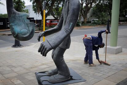 Un empleado limpia una de las calles de la Keyes Art Mile, zona conocida por su arte y arquitectura, en Johannesburgo (Sudáfrica).