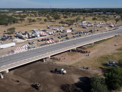 Varios camiones limpian el terreno donde se encontraba el campamento de migrantes haitianos bajo el puente internacional en Del Río (Texas), este viernes.