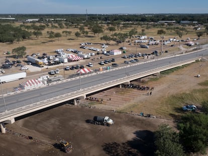 Varios camiones limpian el terreno donde se encontraba el campamento de migrantes haitianos bajo el puente internacional en Del Río (Texas), este viernes.