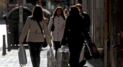 Varias mujeres pasean por una calle del centro de Valencia cargadas con bolsas con compras.