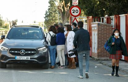 Una alumna y varios periodistas en una de las puertas del colegio Monteagudo, en Murcia, donde un docente fue apuñalado presuntamente por un alumno en febrero de 2022.