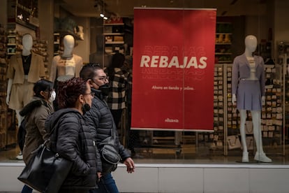 Transeúntes pasan frente una tienda de ropa con rebajas  en la calle Francisco I. Madero de Ciudad de México.