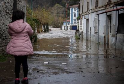 Una niña observa el río Deba, desbordado a su paso por la localidad guipuzcoana de Mendaro. Como consecuencia de la crecida, no es posible acceder por carretera a Mendaro.