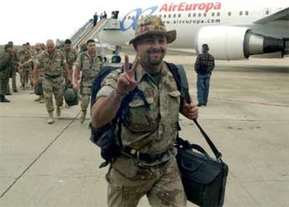 Un soldado hace la señal de la victoria en la pista donde ha aterrizado el avión B-767, que ha traído de vuelta a España a 60 militares.