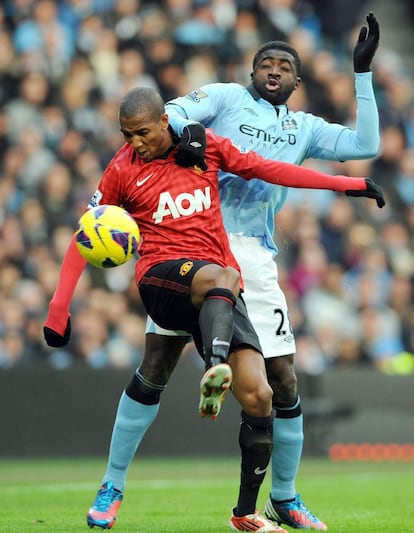 Ashley Young pugna por el balón con Kolo Toure