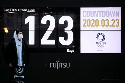 Un hombre pasa ante un reloj con la cuenta atrás para el teórico inicio de los Juegos de Tokyo.