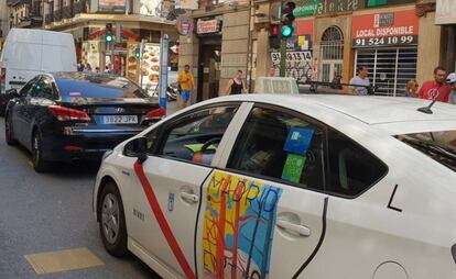 Un taxi y un vehículo con licencia VTC, en Madrid.