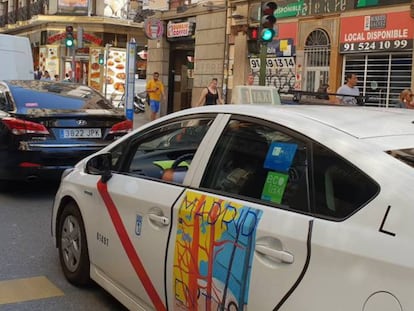 Un taxi y un vehículo con licencia VTC, en Madrid.