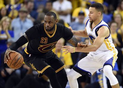 Curry trata de frenar a LeBron.