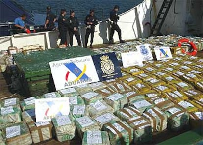 Agentes del Cuerpo Nacional de Policía junto a los fardos que contienen la cocaína, expuestos en la cubierta del pesquero senegalés.