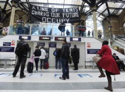 Maniestantes del movimiento "Occupy London" despliegan una pancarta en la estación de metro de Liverpool Street en Londres (Reino Unido). EFE/Archivo