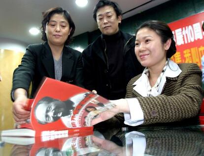 Kong Dongmei firma aut&oacute;grafos en la biograf&iacute;a de su abuelo, Mao Zedong.