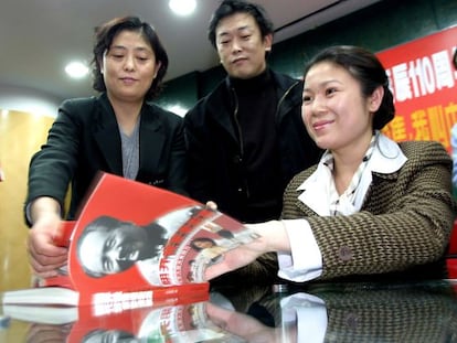 Kong Dongmei firma autógrafos en la biografía de su abuelo, Mao Zedong.