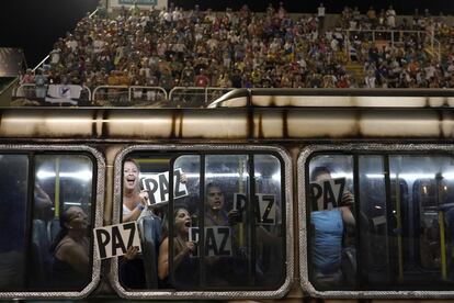 Miembros de la escuela de samba Uniao da Ilha sostienen carteles en los que se lee "Paz" mientras desfilan durante las celebraciones del carnaval en el Sambódromo de Río de Janeiro.