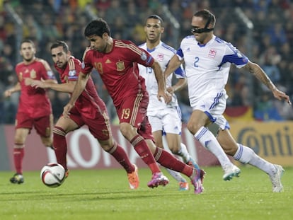 Diego Costa se escapa con el bal&oacute;n de dos defensores de Luxemburgo, con Paco Alc&aacute;cer tras &eacute;l.