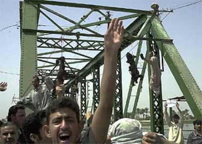 Un grupo de iraquíes grita contra EE UU tras colgar de un puente sobre el Tigris los cadáveres quemados de dos civiles extranjeros en Faluya.