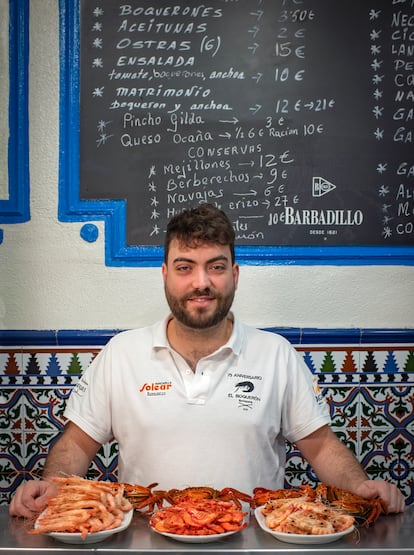 Daniel Simón, hijo del dueño del bar El Boquerón, en la barra de la taberna junto a tres platos de marisco. 