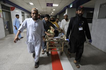 People transport a man, who was injured after a blast in Bajaur district of Khyber Pakhtunkhwa, at the Lady Reading Hospital in Peshawar, Pakistan, on July 30, 2023.